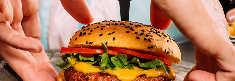 Sanduíche suculento com alface e tomate sendo preparado